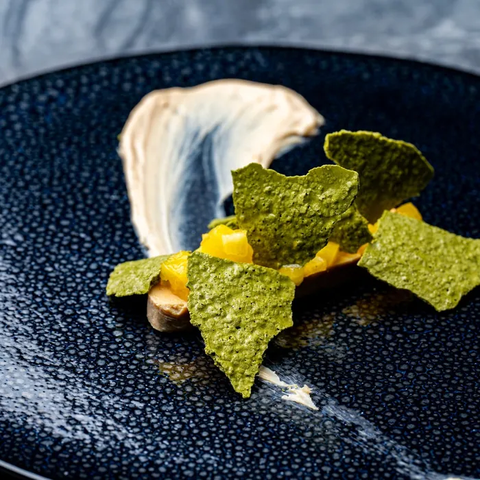 A dish at ars served on a navy plate